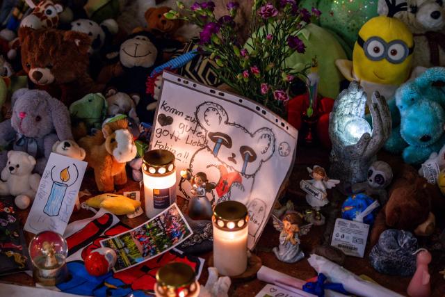 30 October 2025, Mecklenburg-Western Pomerania, Guestrow: Visitors to the funeral service for eight-year-old Fabian place candles among cuddly toys at the entrance to St. Mary's Church. The boy's body was found in a forest near Guestrow on 14 October 2025, four days after he went missing. Photo: Jens Büttner/dpa