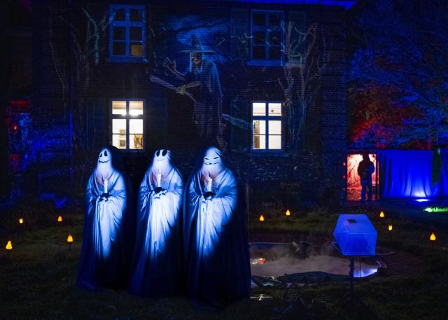 30 October 2025, Hesse, Frankfurt_Main: Illuminated ghost figures and projections on the facade transform a residential building in Frankfurt into a 'haunted house' ahead of Halloween. Photo: Boris Roessler/dpa - ACHTUNG: Nur zur redaktionellen Verwendung im Zusammenhang mit der aktuellen Berichterstattung zu Halloween 2025 und nur im vollen Format