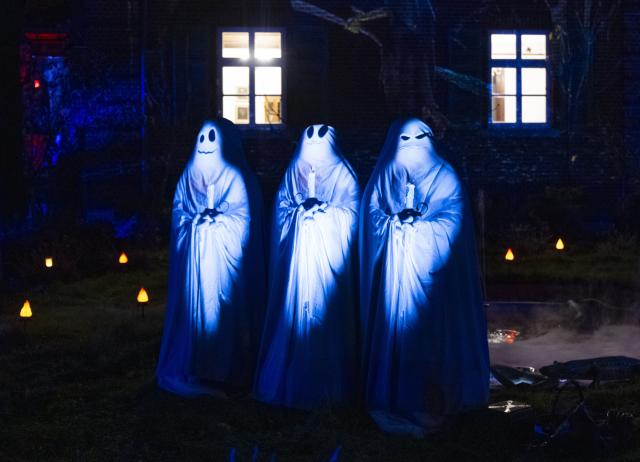 30 October 2025, Hesse, Frankfurt_Main: Illuminated ghost figures and projections on the facade transform a residential building in Frankfurt into a 'haunted house' ahead of Halloween. Photo: Boris Roessler/dpa