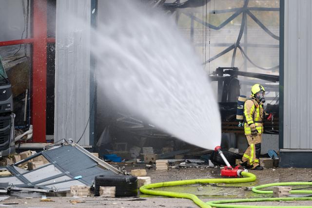 31 October 2025, North Rhine-Westphalia, Castrop-Rauxel: The fire department extinguishes a fire. Four people were injured, two of them seriously, in a fire in a hall at a petrol station in Castrop-Rauxel. According to the police, there had been an explosion. Photo: Bernd Thissen/dpa