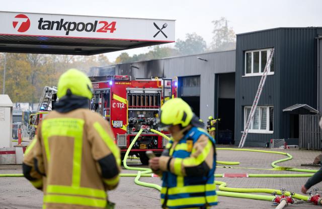 31 October 2025, North Rhine-Westphalia, Castrop-Rauxel: The fire department extinguishes a fire. Four people were injured, two of them seriously, in a fire in a hall at a petrol station in Castrop-Rauxel. According to the police, there had been an explosion. Photo: Bernd Thissen/dpa