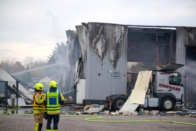 31 October 2025, North Rhine-Westphalia, Castrop-Rauxel: The fire department extinguishes a fire. Four people were injured, two of them seriously, in a fire in a hall at a petrol station in Castrop-Rauxel. According to the police, there had been an explosion. Photo: Bernd Thissen/dpa