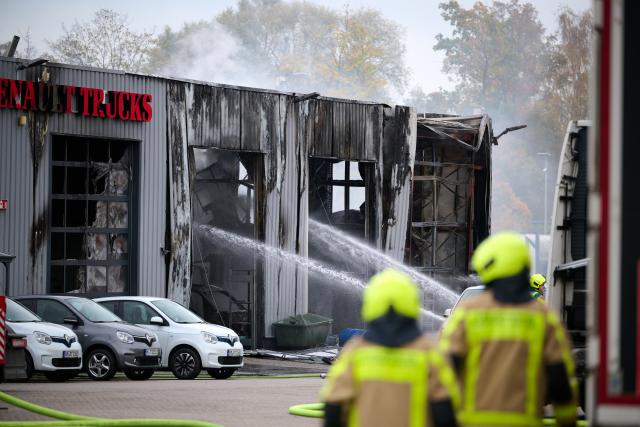 31 October 2025, North Rhine-Westphalia, Castrop-Rauxel: The fire department extinguishes a fire. Four people were injured, two of them seriously, in a fire in a hall at a petrol station in Castrop-Rauxel. According to the police, there had been an explosion. Photo: Bernd Thissen/dpa