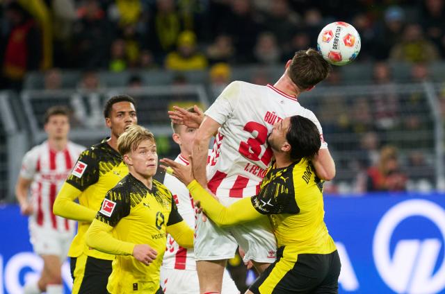 FILED - 25 October 2025, North Rhine-Westphalia, Dortmund: Cologne's Marius Buelter (2nd R) in action against Borussia Dortmund's Daniel Svensson and Ramy Bensebaini during the German Bundesliga soccer match between Borussia Dortmund and 1. FC Cologne at the Signal Iduna Park. Photo: Bernd Thissen/dpa - IMPORTANT NOTICE: DFL and DFB regulations prohibit any use of photographs as image sequences and/or quasi-video.
