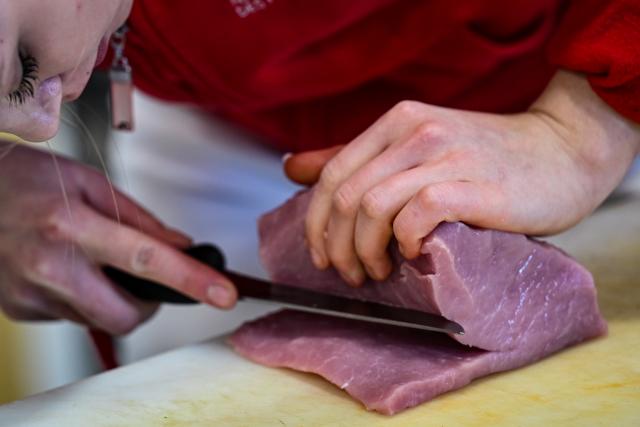 FILED - 22 November 2021, Hessen, Weiterstadt: A member of the German national butchery team, cuts pork for a rolled roast. South Korea has lifted a ban on pork imports from Germany imposed after an outbreak of foot-and-mouth disease (FMD) in the country some 10 months earlier, German officials said on Friday. Photo: Arne Dedert/dpa