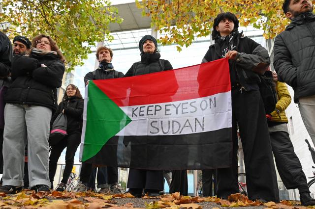 31 October 2025, Berlin: Participants hold a Sudanese flag with the inscription "Keep Eyes on Sudan" during a vigil under the motto "Stand with Sudan - Stop the massacres in Al-Fasher" in front of the Federal Foreign Office. Photo: Elisa Schu/dpa