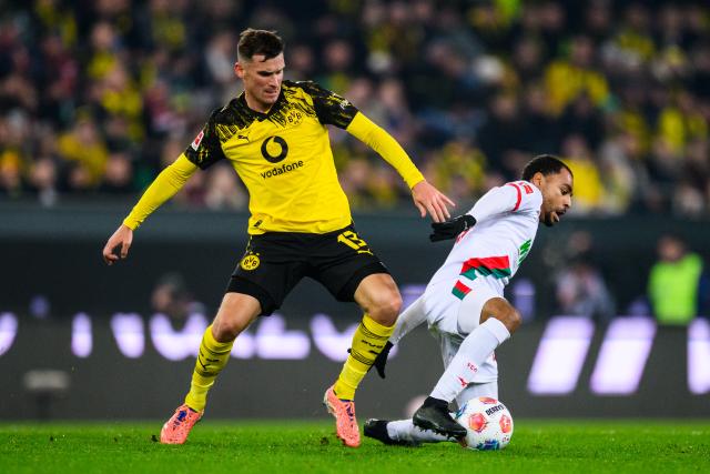31 October 2025, Bavaria, Augsburg: Borussia Dortmund's Pascal Gross (L) and Augsburg's Alexis Claude-Maurice battle for the ball during the German Bundesliga soccer match between FC Augsburg and Borussia Dortmund at WWK-Arena. Photo: Tom Weller/dpa - WICHTIGER HINWEIS: Gemäß den Vorgaben der DFL Deutsche Fußball Liga bzw. des DFB Deutscher Fußball-Bund ist es untersagt, in dem Stadion und/oder vom Spiel angefertigte Fotoaufnahmen in Form von Sequenzbildern und/oder videoähnlichen Fotostrecken zu verwerten bzw. verwerten zu lassen.