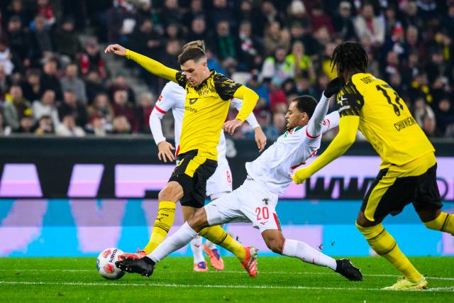31 October 2025, Bavaria, Augsburg: Borussia Dortmund's Pascal Gross (L) and Augsburg's Alexis Claude-Maurice battle for the ball during the German Bundesliga soccer match between FC Augsburg and Borussia Dortmund at WWK-Arena. Photo: Tom Weller/dpa - WICHTIGER HINWEIS: Gemäß den Vorgaben der DFL Deutsche Fußball Liga bzw. des DFB Deutscher Fußball-Bund ist es untersagt, in dem Stadion und/oder vom Spiel angefertigte Fotoaufnahmen in Form von Sequenzbildern und/oder videoähnlichen Fotostrecken zu verwerten bzw. verwerten zu lassen.