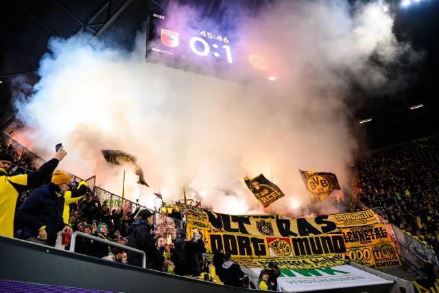31 October 2025, Bavaria, Augsburg: Borussia Dortmund fans set off pyrotechnics in the fan block during the German Bundesliga soccer match between FC Augsburg and Borussia Dortmund at WWK-Arena. Photo: Tom Weller/dpa - WICHTIGER HINWEIS: Gemäß den Vorgaben der DFL Deutsche Fußball Liga bzw. des DFB Deutscher Fußball-Bund ist es untersagt, in dem Stadion und/oder vom Spiel angefertigte Fotoaufnahmen in Form von Sequenzbildern und/oder videoähnlichen Fotostrecken zu verwerten bzw. verwerten zu lassen.