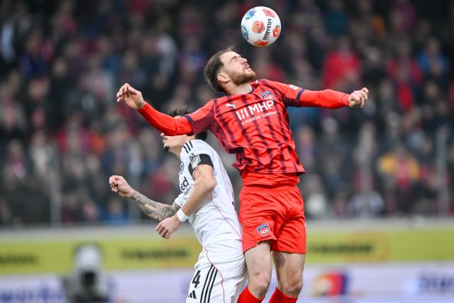 01 November 2025, Baden-Wuerttemberg, Heidenheim: Eintracht Frankfurt's Robin Koch (L) and Heidenheim's Budu Zivzivadze battle for the ball during the German Bundesliga soccer match between 1. FC Heidenheim and Eintracht Frankfurt at Voith-Arena. Photo: Harry Langer/dpa - WICHTIGER HINWEIS: Gemäß den Vorgaben der DFL Deutsche Fußball Liga bzw. des DFB Deutscher Fußball-Bund ist es untersagt, in dem Stadion und/oder vom Spiel angefertigte Fotoaufnahmen in Form von Sequenzbildern und/oder videoähnlichen Fotostrecken zu verwerten bzw. verwerten zu lassen.