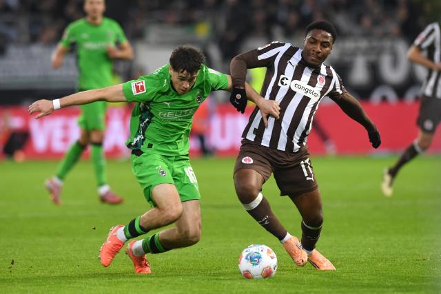 01 November 2025, Hamburg: Moenchengladbach's Philipp Sander (L) and Hamburg's Oladapo Afolayan battle for the ball during the German Bundesliga soccer match between FC St. Pauli and Borussia Moenchengladbach at the Millerntorstadion. Photo: Daniel Bockwoldt/dpa - WICHTIGER HINWEIS: Gemäß den Vorgaben der DFL Deutsche Fußball Liga bzw. des DFB Deutscher Fußball-Bund ist es untersagt, in dem Stadion und/oder vom Spiel angefertigte Fotoaufnahmen in Form von Sequenzbildern und/oder videoähnlichen Fotostrecken zu verwerten bzw. verwerten zu lassen.