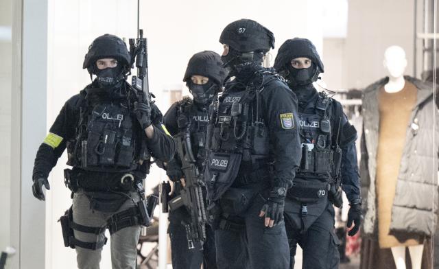 01 November 2025, Hesse, Frankfurt/Main: Heavily armed police officers comb the Northwest Center in Frankfurt, after the shopping center was evacuated. Photo: Boris Roessler/dpa