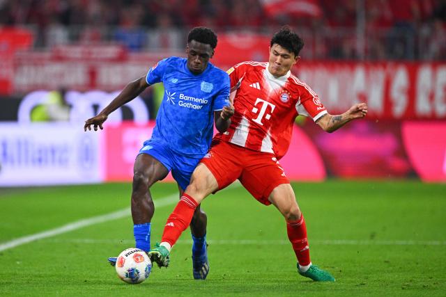 01 November 2025, Bavaria, Munich: Bayern Munich's Min-jae Kim (R) and Bayer Leverkusen's Ernest Poku battle for the ball during the German Bundesliga soccer match between FC Bayern Munich and Bayer Leverkusen at Allianz Arena. Photo: Tom Weller/dpa - IMPORTANT NOTICE: DFL and DFB regulations prohibit any use of photographs as image sequences and/or quasi-video.
