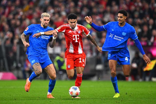 01 November 2025, Bavaria, Munich: Bayern Munich's Luis Diaz (C) battles for the ball with Bayer Leverkusen's Robert Andrich (L) and Jarell Quansah during the German Bundesliga soccer match between FC Bayern Munich and Bayer Leverkusen at Allianz Arena. Photo: Tom Weller/dpa - IMPORTANT NOTICE: DFL and DFB regulations prohibit any use of photographs as image sequences and/or quasi-video.