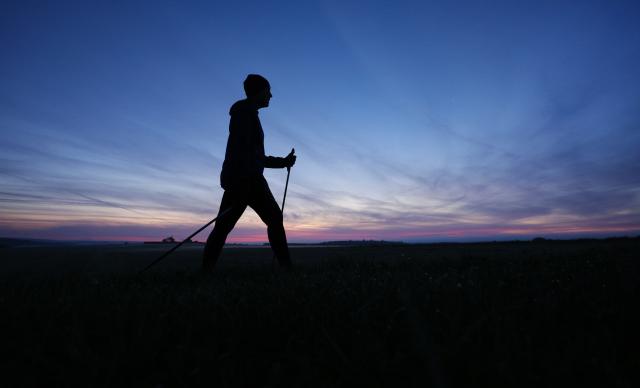 FILED - 07 September 2025, Baden-Wuerttemberg, Unlingen: A woman walks with Nordic walking sticks before sunrise in Unlingen. A recent scientific study conducted in the United States and Australia revealed that walking or exercising for a continuous period of 10 to 15 minutes daily is better than walking several times a day for five minutes at a time, in reducing the risk of heart disease and premature death, especially for people who lead sedentary or less active lifestyles, even if they take the same number of steps daily. Photo: Thomas Warnack/dpa