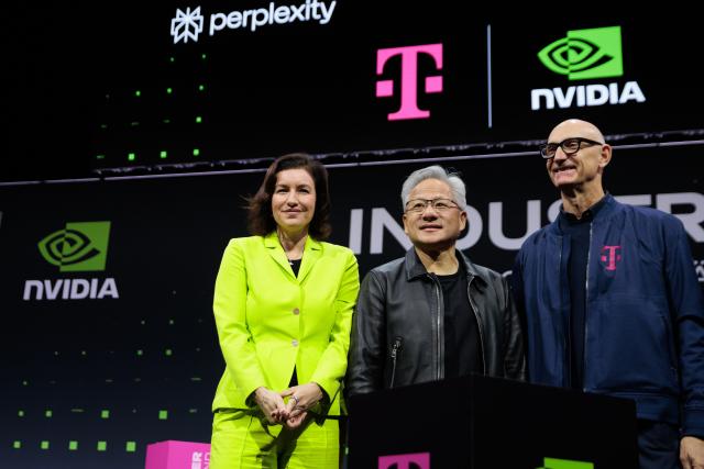 04 November 2025, Berlin: Dorothee Baer (L), Germany's Minister for Research, Technology and Space, Jensen Huang (C), CEO of NVIDIA, and Tim Hoettges (R), CEO of Deutsche Telekom AG, attend the presentation of a new AI factory jointly developed by Deutsche Telekom and NVIDIA. The collaboration aims to lay the foundation for a new era of artificial intelligence (AI) in Germany and across Europe. Photo: Carsten Koall/dpa