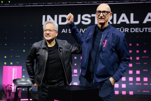 04 November 2025, Berlin: Jensen Huang (L), CEO of NVIDIA, and Tim Hoettges (R), CEO of Deutsche Telekom AG, present a new AI factory jointly developed by Deutsche Telekom and NVIDIA. The collaboration aims to lay the foundation for a new era of artificial intelligence (AI) in Germany and Europe. Photo: Carsten Koall/dpa