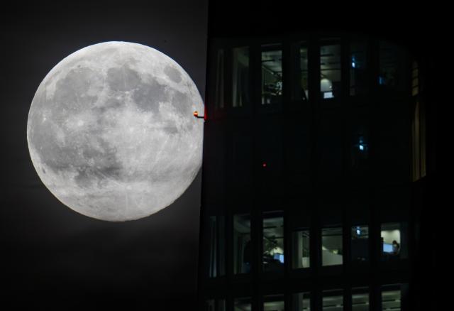 05 November 2025, Hesse, Frankfurt_Main: The full moon seen next to the illuminated office windows of the European Central Bank (ECB) in the sky. Photo: Boris Roessler/dpa