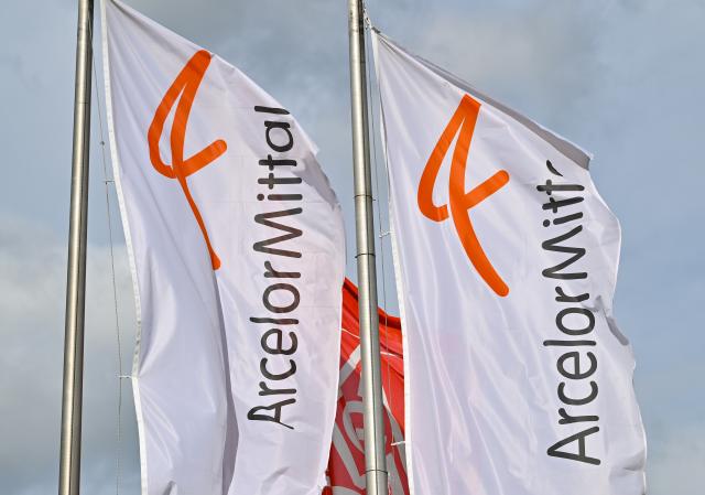 FILED - 14 March 2023, Brandenburg, Eisenhuettenstadt: Flags of the steel producer ArcelorMittal wave in the wind. Photo: Patrick Pleul/dpa