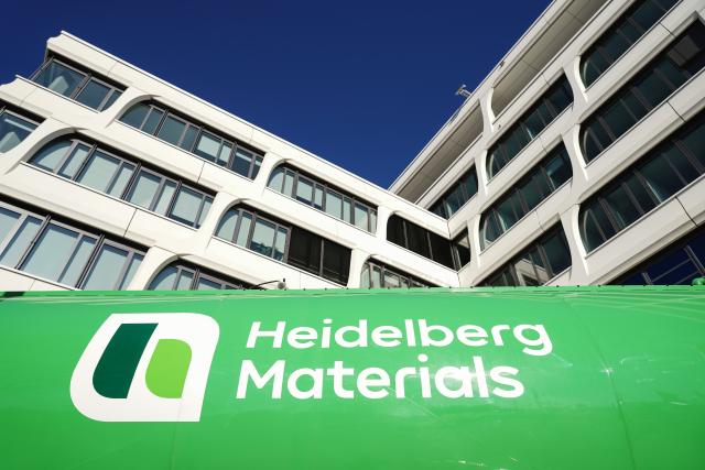 FILED - 13 February 2023, Baden-Wuerttemberg, Heidelberg: A company logo of the building materials group "Heidelberg Materials", is attached to a truck trailer parked in front of the company headquarters. German building materials company Heidelberg Materials reported on Thursday higher results from current operations in the third quarter compared to the same period of the previous year, with growth in revenues. Photo: Uwe Anspach/dpa