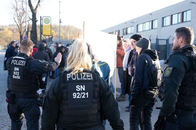 06 November 2025, Saxony, Dresden: Police officers stand in front of rally participants holding a banner reading 'The problem is still racism!' outside the Higher Regional Court (OLG). The rally marks the start of the trial against an alleged confidant of NSU terrorist Beate Zschaepe, accused of supporting a terrorist organization, among other charges. Photo: Sebastian Kahnert/dpa