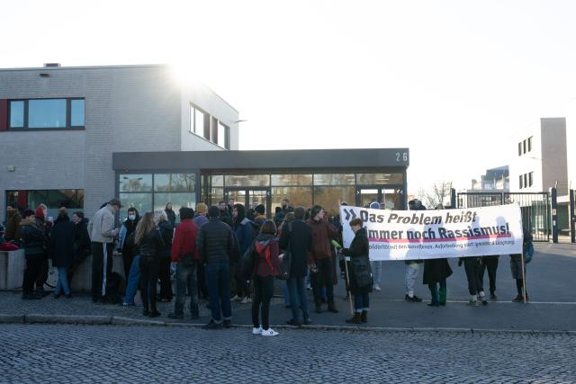 06 November 2025, Saxony, Dresden: Participants in a rally stand in front of the Higher Regional Court (OLG) with a banner reading "We are sticking to it - anti-fascism is our answer." The rally marks the start of the trial against an alleged confidant of NSU terrorist Beate Zschaepe, accused of supporting a terrorist organization, among other charges. Photo: Sebastian Kahnert/dpa