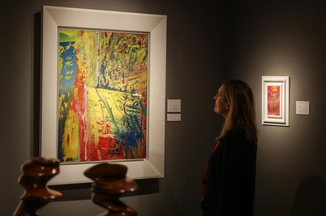 06 November 2025, North Rhine-Westphalia, Cologne: A gallery owner stands in front of the painting "U.L." by Gerhard Richter, during the Art Cologne art fair, which will take place in Cologne from November 6 to 9. Photo: Oliver Berg/dpa - ACHTUNG: Nur zur redaktionellen Verwendung im Zusammenhang mit der aktuellen Berichterstattung über die Art Cologne und nur mit vollständiger Nennung des vorstehenden Credits