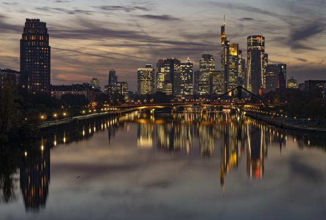06 November 2025, Hesse, Frankfurt/Main: The lights of the Frankfurt skyline are reflected in the waters of the Main. Photo: Boris Roessler/dpa