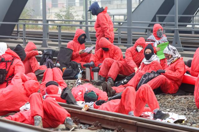 07 November 2025, Hamburg: Activists from the "Ende Gelaende" group and Palestine solidarity groups have occupied and blocked rail tracks on the Waltershofer Bridge in the port of Hamburg, calling for a stop to arms exports to Israel. Photo: Bodo Marks/dpa