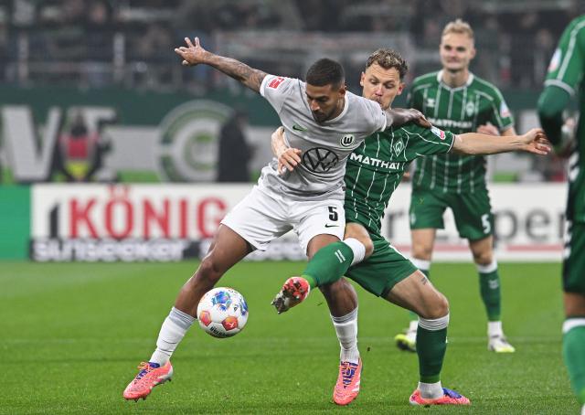 07 November 2025, Bremen: Werder Bremen's Senne Lynen (R) and Wolfsburg's Vinicius Souza battle for the ball during the German Bundesliga soccer match between Werder Bremen and VfL Wolfsburg, at the Weser Stadium. Photo: Carmen Jaspersen/dpa - IMPORTANT NOTICE: DFL and DFB regulations prohibit any use of photographs as image sequences and/or quasi-video.