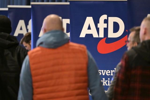 08 November 2025, Brandenburg, Brandenburg an der Havel: Participants walk past banners of the Alternative for Germany (AfD) during the party's state conference at the Stahlapalast in Brandenburg. Photo: Michael Bahlo/dpa