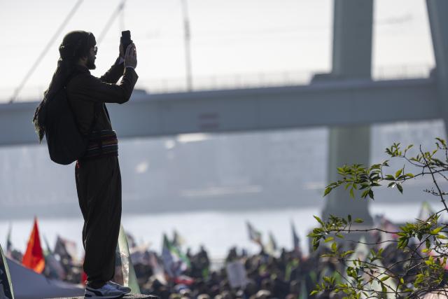 08 November 2025, Nordrhein-Westfalen, Cologne: A participant take a photo during the large-scale Kurdish demonstration in Cologne. Photo: Thomas Banneyer/dpa