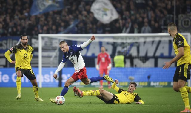 08 November 2025, Hamburg: Hamburger's Miro Muheim (Center L) and Borussia Dortmund's Pascal Gross (Center R) battle for the ball during the German Bundesliga soccer match between Hamburger SV and Borussia Dortmund at Volksparkstadion. Photo: Christian Charisius/dpa - IMPORTANT NOTICE: DFL and DFB regulations prohibit any use of photographs as image sequences and/or quasi-video.