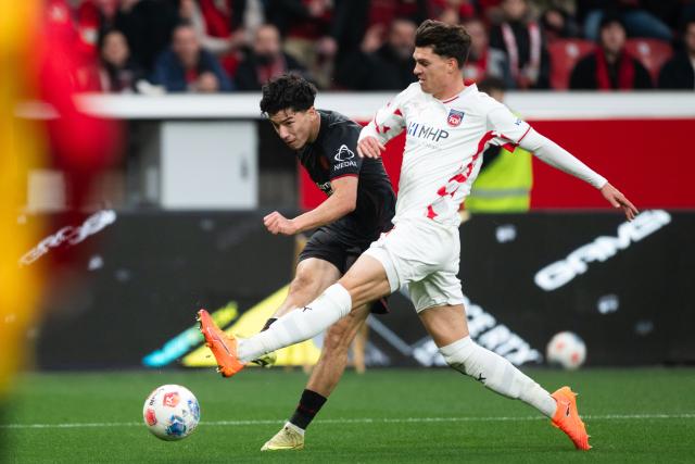 08 November 2025, North Rhine-Westphalia, Leverkusen: Bayer Leverkusen's Ibrahim Maza (L) and Heidenheim's Mathias Honsak battle for the ball during the German Bundesliga soccer match between Bayer 04 Leverkusen and 1. FC Heidenheim at BayArena. Photo: Marius Becker/dpa - IMPORTANT NOTICE: DFL and DFB regulations prohibit any use of photographs as image sequences and/or quasi-video.