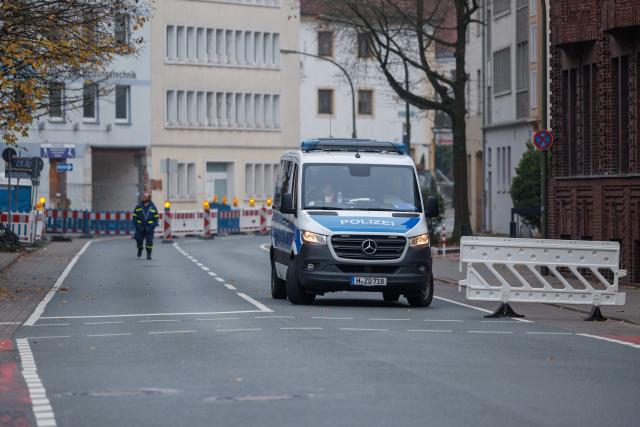 09 November 2025, Lower Saxony, Osnabrück: A police vehicle is parked on a closed road. During construction work, four possible sites of unexploded bombs from the Second World War were identified. More than 14,000 people within an evacuation radius of one kilometer must therefore leave their homes by 07:00. The Marienhospital, the Christian Children's Hospital and the main railway station are also affected. Photo: Friso Gentsch/dpa
