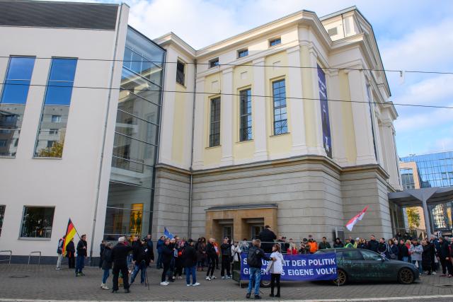 09 November 2025, Saxony-Anhalt, Magdeburg: People take part in a demonstration in front of Magdeburg Opera House against the planned play "3 Minutes", which is to be based on the attack on Magdeburg's Christmas market in December 2024. Photo: Klaus-Dietmar Gabbert/dpa