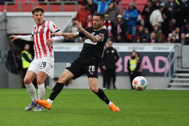 09 November 2025, Baden-Wuerttemberg, Freiburg im Breisgau: Freiburg's Philipp Treu (L) and St. Pauli's Mathias Pereira Lage battle for the ball during the German Bundesliga soccer match between SC Freiburg and FC St. Pauli at Europa-Park Stadium. Photo: Philipp von Ditfurth/dpa - WICHTIGER HINWEIS: Gemäß den Vorgaben der DFL Deutsche Fußball Liga bzw. des DFB Deutscher Fußball-Bund ist es untersagt, in dem Stadion und/oder vom Spiel angefertigte Fotoaufnahmen in Form von Sequenzbildern und/oder videoähnlichen Fotostrecken zu verwerten bzw. verwerten zu lassen.