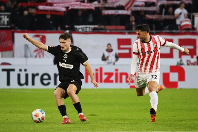 09 November 2025, Baden-Wuerttemberg, Freiburg im Breisgau: Freiburg's Vincenzo Grifo (R) and St. Pauli's Arkadiusz Pyrka battle for the ball during the German Bundesliga soccer match between SC Freiburg and FC St. Pauli at Europa-Park Stadium. Photo: Philipp von Ditfurth/dpa - WICHTIGER HINWEIS: Gemäß den Vorgaben der DFL Deutsche Fußball Liga bzw. des DFB Deutscher Fußball-Bund ist es untersagt, in dem Stadion und/oder vom Spiel angefertigte Fotoaufnahmen in Form von Sequenzbildern und/oder videoähnlichen Fotostrecken zu verwerten bzw. verwerten zu lassen.