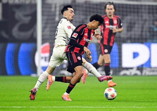 09 November 2025, Hesse, Frankfurt/Main: Eintracht Frankfurt's Nathaniel Brown (R) and Mainz's Paul Nebel battle for the ball during the German Bundesliga soccer match between Eintracht Frankfurt and 1. FSV Mainz 05 at Deutsche Bank Park. Photo: Arne Dedert/dpa - WICHTIGER HINWEIS: Gemäß den Vorgaben der DFL Deutsche Fußball Liga bzw. des DFB Deutscher Fußball-Bund ist es untersagt, in dem Stadion und/oder vom Spiel angefertigte Fotoaufnahmen in Form von Sequenzbildern und/oder videoähnlichen Fotostrecken zu verwerten bzw. verwerten zu lassen.