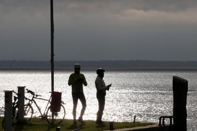 10 November 2025, Mecklenburg-Western Pomerania, Ahrenshoop: Dark clouds have gathered over the Bodden, the light of the sun is reflected in the water. Calm autumn weather with lots of dark clouds and sunny spells dominates the north. Photo: Bernd Wüstneck/dpa
