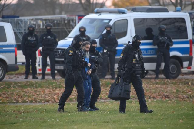 10 November 2025, Saxony-Anhalt, Magdeburg: Judicial officers lead Taleb al-Abdulmohsen to a helicopter on the grounds of the state riot police. The trial of Taleb al-Abdulmohsen, who drove over the Magdeburg Christmas market on December 20, 2024, began in the morning. Photo: Klaus-Dietmar Gabbert/dpa