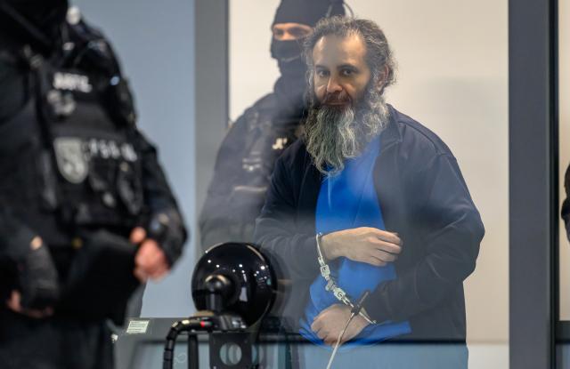 11 November 2025, Saxony-Anhalt, Magdeburg: The defendant Taleb al-Abdulmohsen stands in a bullet-proof glass box in the temporary court building at Magdeburg Regional Court at the start of the second day of the trial. The public prosecutor's office is accusing the man from Saudi Arabia of attempted murder in 338 cases. On December 20, 2024, Taleb al-Abdulmohsen drove into a crowd of people at the Magdeburg Christmas market. Five women and a child died in the attack and more than 300 people were injured. Photo: Hendrik Schmidt/dpa