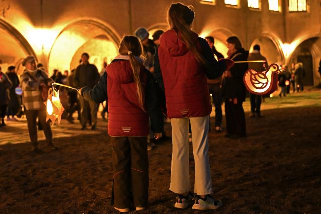 11 November 2025, Saxony-Anhalt, Halle: Two girls stand in the courtyard of Moritzburg Castle with their lanterns on St. Martin's Day. In the Catholic Church, November 11 is dedicated to the Bishop of Tours, who is revered as a saint. Photo: Jennifer Brückner/dpa