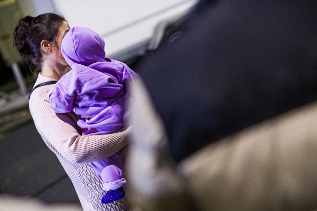11 November 2025, Lower Saxony, Langenhagen: A mother from Afghanistan, who previously landed with her child on a plane at Hanover-Langenhagen Airport, stands in front of the airport. Afghans who have been accepted for admission are said to have arrived in Hanover on a scheduled flight. Photo: Moritz Frankenberg/dpa