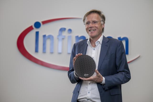 12 November 2025, Bavaria, Neubiberg: Jochen Hanebeck, CEO of Infineon Technologies AG, holds a waver with ion trap quantum processors in his hands before the start of the presentation of the semiconductor company's annual figures for 2025. Photo: Peter Kneffel/dpa