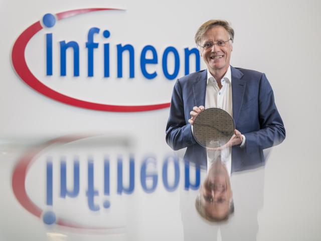12 November 2025, Bavaria, Neubiberg: Jochen Hanebeck, CEO of Infineon Technologies AG, holds a waver with ion trap quantum processors in his hands before the start of the presentation of the semiconductor company's 2025 annual figures. Photo: Peter Kneffel/dpa