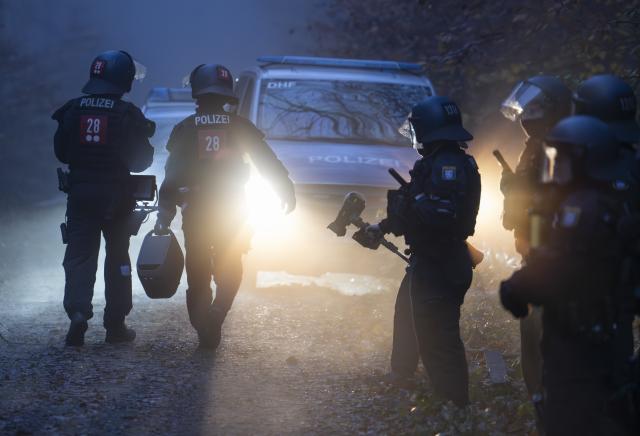 12 November 2025, Hesse, Langen: Police officers begin cordoning off an activist camp ahead of its eviction. Activists occupied the forest near Langen several months ago and have since erected numerous tree houses. Photo: Boris Roessler/dpa