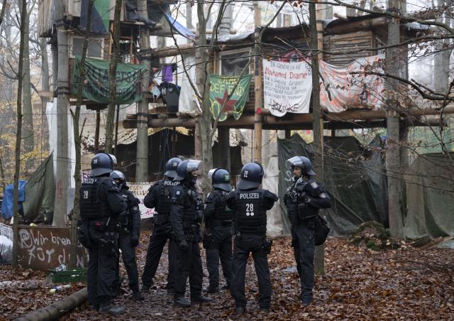 12 November 2025, Hesse, Langen: Police officers begin cordoning off an activist camp ahead of its eviction. Activists occupied the forest near Langen several months ago and have since erected numerous tree houses. Photo: Boris Roessler/dpa