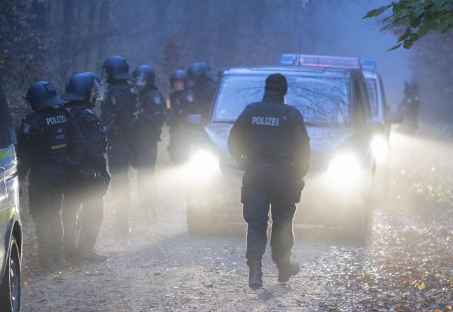 12 November 2025, Hesse, Langen: Police officers begin cordoning off an activist camp ahead of its eviction. Activists occupied the forest near Langen several months ago and have since erected numerous tree houses. Photo: Boris Roessler/dpa