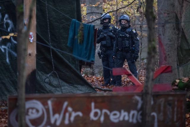 12 November 2025, Hesse, Langen: Police officers begin cordoning off an activist camp ahead of its eviction. Activists occupied the forest near Langen several months ago and have since erected numerous tree houses. Photo: Boris Roessler/dpa